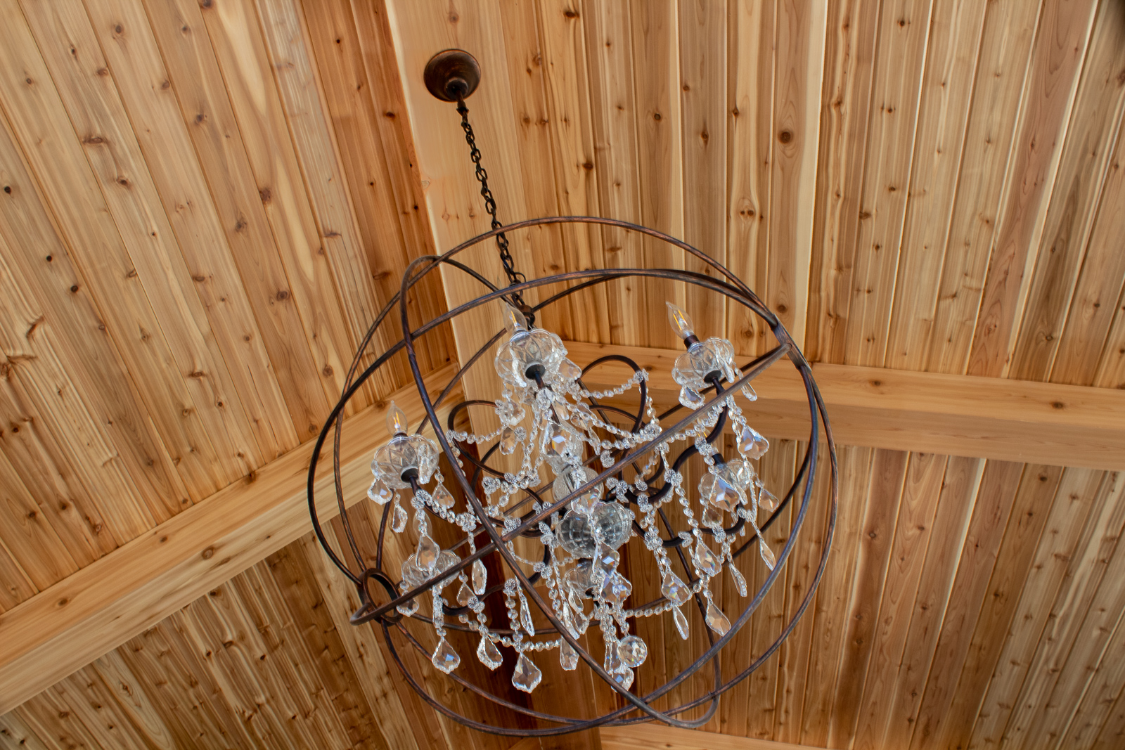 Crystal orb chandelier cedar wood stained ceiling