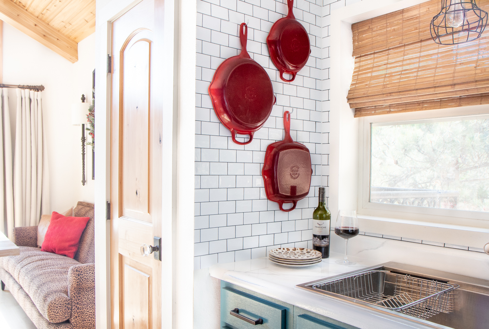 Red Le Creuset pans on wall